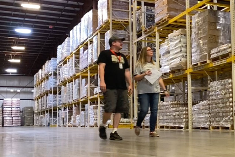Two people walking through the warehouse